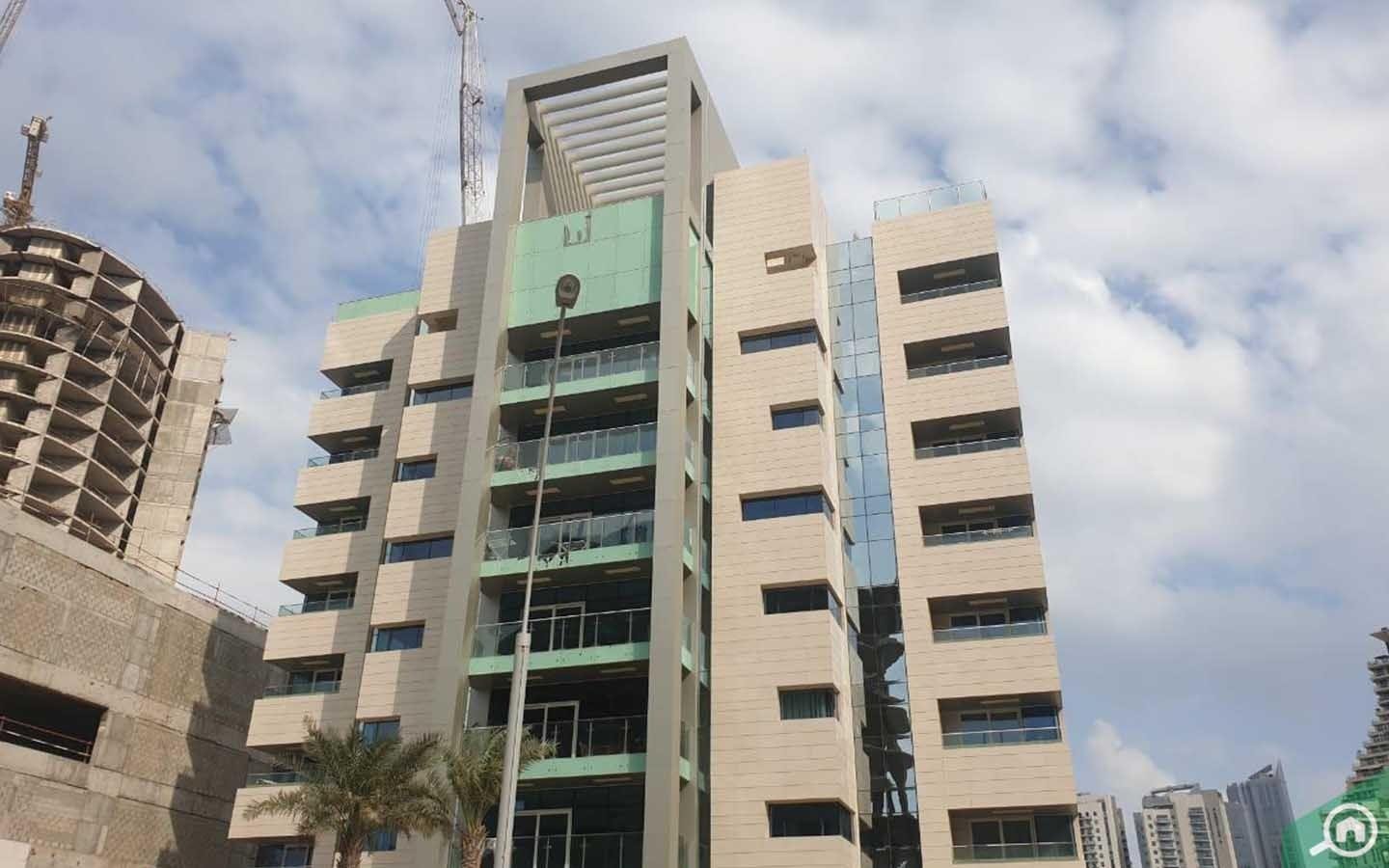 Low-rise 9-story modern residential building Boardwalk Residence at City of Lights, Al Reem Island, featuring sleek modern architecture, floor-to-ceiling glass balconies, and clear blue sky overhead.